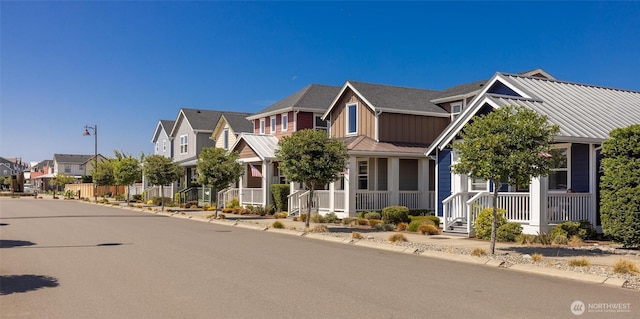 view of front of property featuring a residential view, covered porch, board and batten siding, metal roof, and a standing seam roof