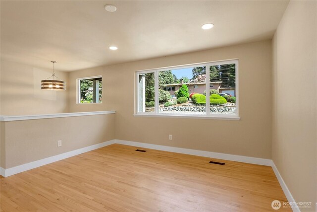spare room with wood finished floors, baseboards, and recessed lighting