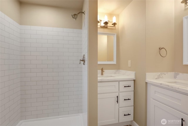 bathroom with a stall shower and two vanities