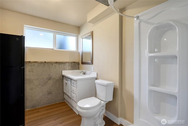 full bathroom featuring wood finished floors, vanity, a shower, and toilet