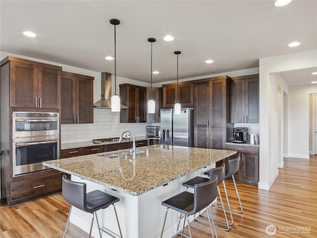 2668 83rd Avenue Ct E, Edgewood, WA 98371 - kitchen with appliances with stainless steel finishes, wall chimney range hood, a sink, tasteful backsplash, and recessed lighting