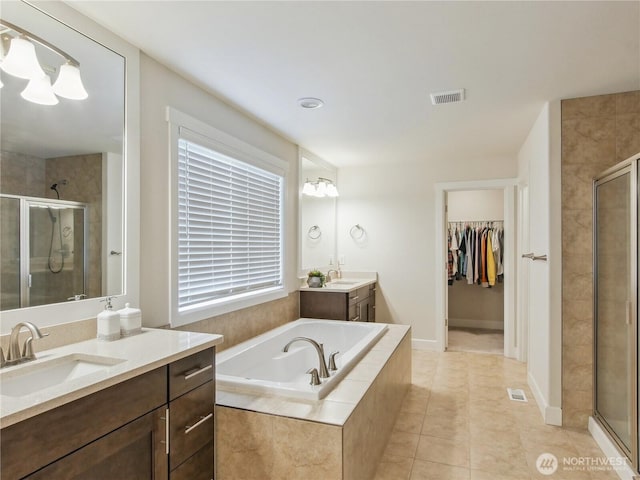 2668 83rd Avenue Ct E, Edgewood, WA 98371 - full bathroom featuring a shower stall, a bath, tile patterned flooring, two vanities, and a walk in closet