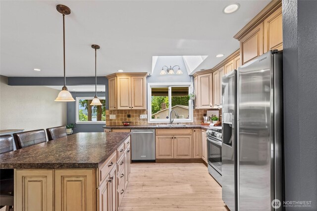 104 Point Fosdick Cir NW, Gig Harbor, WA 98335 - kitchen with stainless steel appliances, a sink, light wood-style flooring, dark countertops, and tasteful backsplash