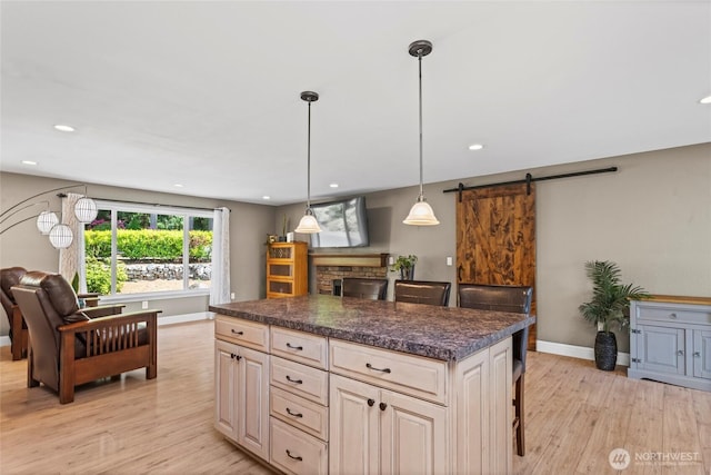 104 Point Fosdick Cir NW, Gig Harbor, WA 98335 - kitchen with a barn door, baseboards, light wood-style floors, dark countertops, and recessed lighting