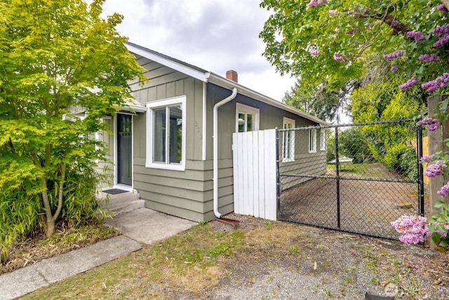213 S 70th St, Tacoma, WA 98408 - view of home's exterior with a chimney and a gate
