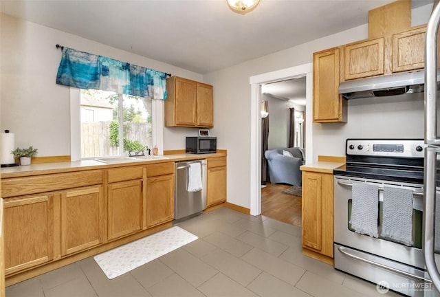 213 S 70th St, Tacoma, WA 98408 - kitchen featuring stainless steel appliances, under cabinet range hood, a sink, and light countertops