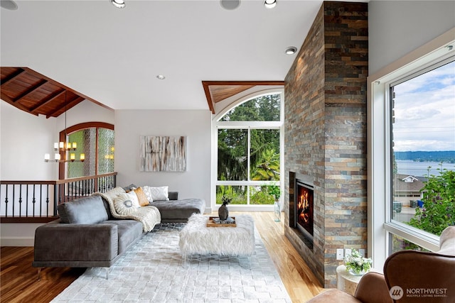 16915 SE 39th St, Bellevue, WA 98008 - living area with wood finished floors, vaulted ceiling, a large fireplace, a chandelier, and baseboards