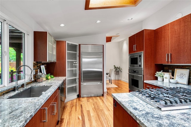 16915 SE 39th St, Bellevue, WA 98008 - kitchen featuring built in appliances, a sink, light wood-style flooring, recessed lighting, and light stone counters