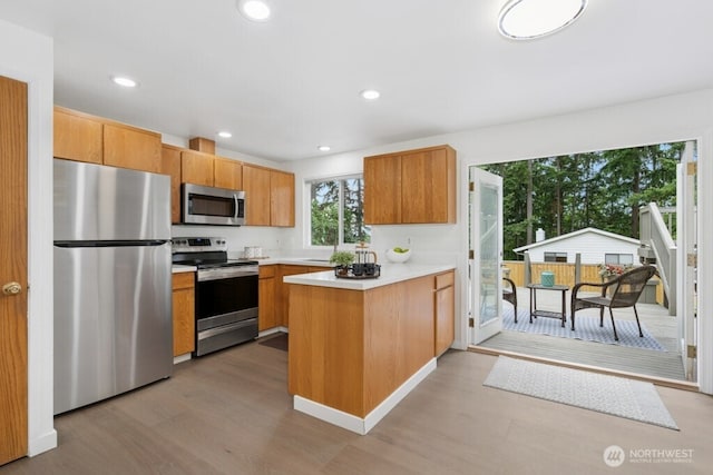 1115 207th Pl NE, Sammamish, WA 98074 - kitchen featuring stainless steel appliances, a peninsula, light wood-style floors, light countertops, and recessed lighting