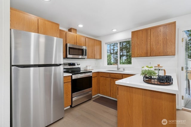 1115 207th Pl NE, Sammamish, WA 98074 - kitchen featuring appliances with stainless steel finishes, light wood-type flooring, a sink, light countertops, and recessed lighting