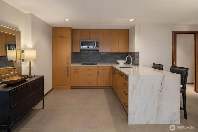 3316 SW 172nd St, Burien, WA 98166 - kitchen featuring stainless steel microwave, a sink, a peninsula, decorative backsplash, and a kitchen breakfast bar