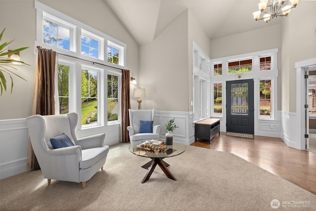 12331 3rd Ave NE, Marysville, WA 98271 - living area with a decorative wall, a chandelier, a towering ceiling, a wainscoted wall, and wood finished floors