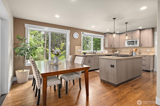 12331 3rd Ave NE, Marysville, WA 98271 - kitchen featuring stainless steel appliances, a kitchen island, light countertops, tasteful backsplash, and a sink