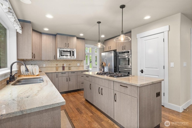 12331 3rd Ave NE, Marysville, WA 98271 - kitchen featuring a sink, appliances with stainless steel finishes, a kitchen island, light stone countertops, and wood finished floors
