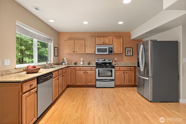 12331 3rd Ave NE, Marysville, WA 98271 - kitchen featuring appliances with stainless steel finishes, a sink, light wood-style floors, light stone counters, and recessed lighting