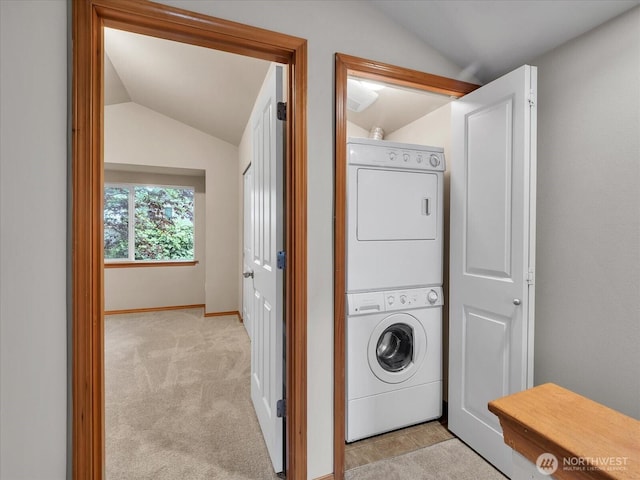 laundry room with stacked washing machine and dryer, light colored carpet, and baseboards