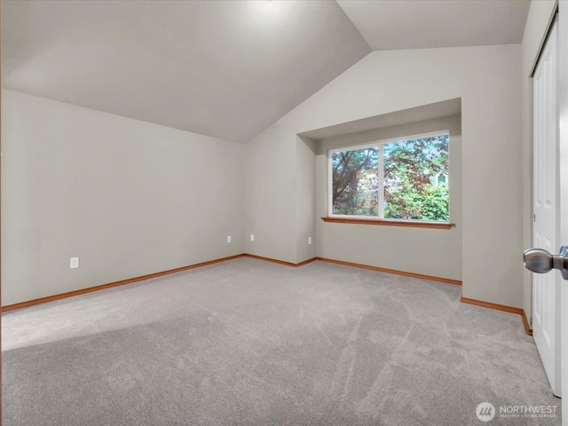bonus room with light carpet, lofted ceiling, and baseboards
