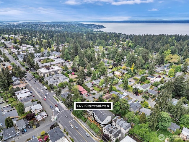 view of property location featuring a large body of water and a heavily wooded area