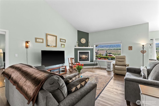 2835 Aspen Shores Dr, East Wenatchee, WA 98802 - living area with hardwood / wood-style flooring, a glass covered fireplace, baseboards, and lofted ceiling