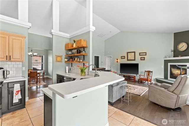 2835 Aspen Shores Dr, East Wenatchee, WA 98802 - kitchen with high vaulted ceiling, a sink, light countertops, open floor plan, and light tile patterned floors