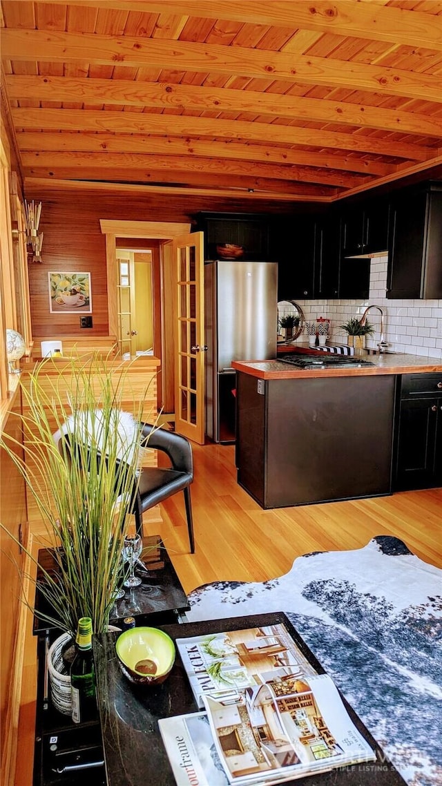 2040 Westlake Ave N Unit 17, Seattle, WA 98109 - kitchen featuring freestanding refrigerator, dark cabinets, wood ceiling, light wood-style floors, and wood walls