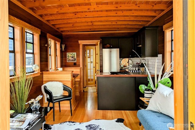 2040 Westlake Ave N Unit 17, Seattle, WA 98109 - kitchen with stainless steel fridge, wooden ceiling, light wood-style floors, wood walls, and dark cabinetry
