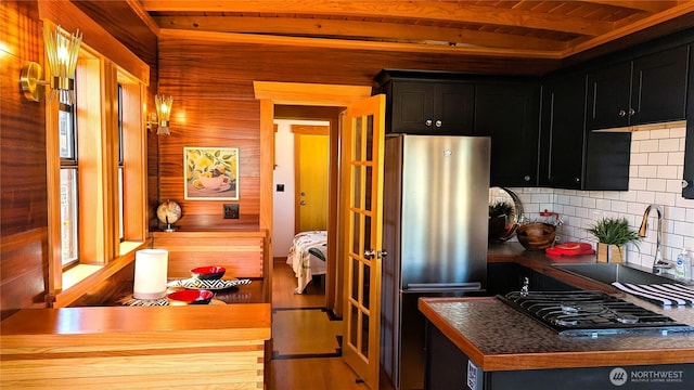 2040 Westlake Ave N Unit 17, Seattle, WA 98109 - kitchen featuring freestanding refrigerator, dark cabinets, black gas stovetop, tasteful backsplash, and dark countertops