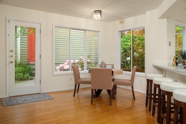 dining area featuring light wood-type flooring and baseboards