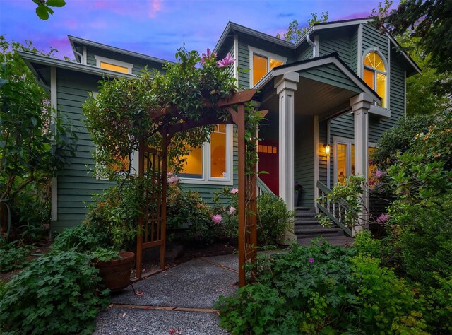 back of house at dusk with covered porch