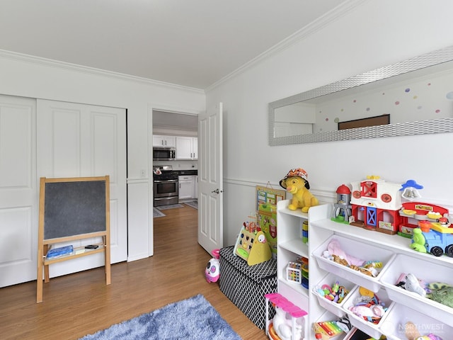 game room with ornamental molding and wood finished floors