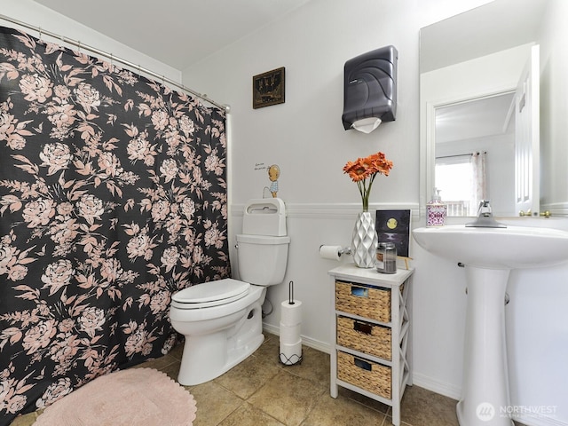 bathroom with toilet, tile patterned flooring, a sink, and a shower with curtain