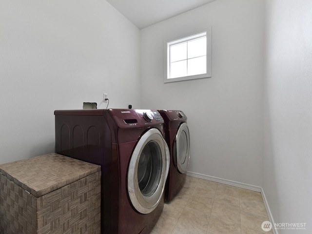 laundry room with washing machine and dryer and baseboards