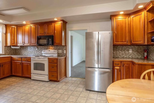 116 E 4th St, Centralia, WA 98531 - kitchen with freestanding refrigerator, black microwave, electric stove, open shelves, and brown cabinets