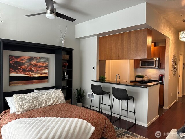 2721 1st Ave Unit 103, Seattle, WA 98121 - bedroom with dark wood-type flooring, a sink, baseboards, and ceiling fan