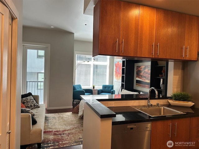 2721 1st Ave Unit 103, Seattle, WA 98121 - kitchen with stainless steel dishwasher, a sink, dark countertops, brown cabinets, and a peninsula