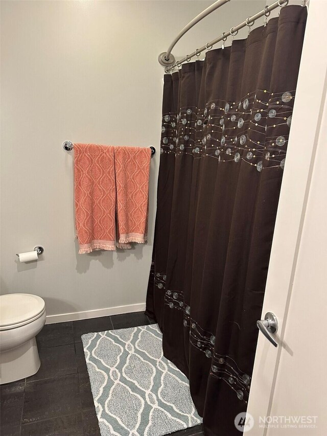 2721 1st Ave Unit 103, Seattle, WA 98121 - bathroom with tile patterned floors, toilet, baseboards, and a shower with shower curtain