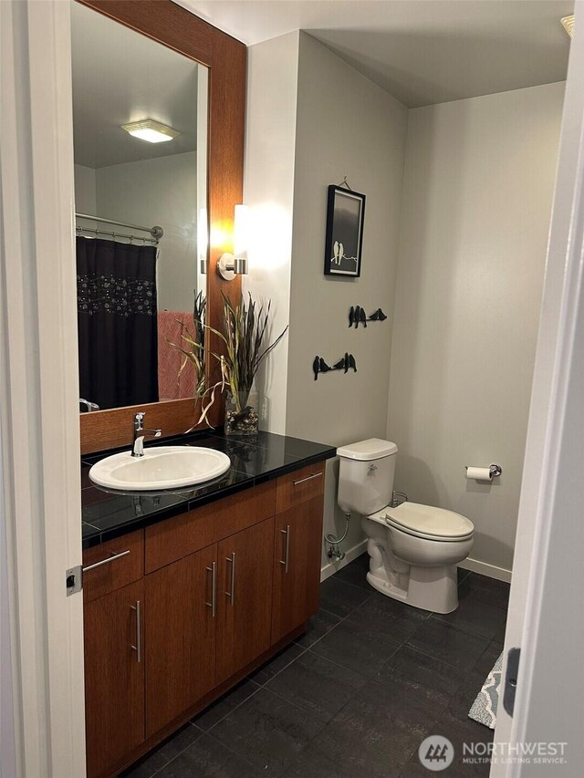 2721 1st Ave Unit 103, Seattle, WA 98121 - full bath featuring toilet, vanity, baseboards, and tile patterned floors