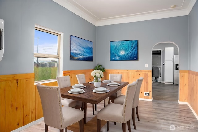 1118 W Wishkah St, Aberdeen, WA 98520 - dining room with wainscoting, arched walkways, wood finished floors, crown molding, and wooden walls