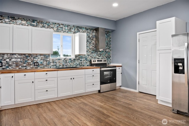 1118 W Wishkah St, Aberdeen, WA 98520 - kitchen featuring butcher block counters, appliances with stainless steel finishes, a sink, wall chimney exhaust hood, and decorative backsplash