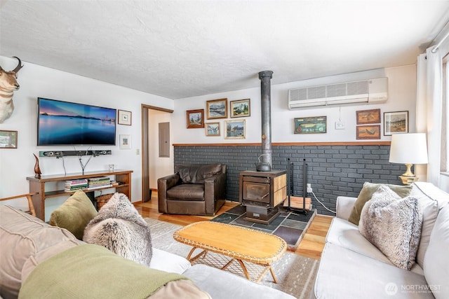 100 Aspen Ln, Packwood, WA 98361 - living area featuring a wall unit AC, wood finished floors, a wood stove, and electric panel