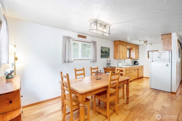 100 Aspen Ln, Packwood, WA 98361 - dining room featuring light wood-style flooring, baseboards, and a textured ceiling