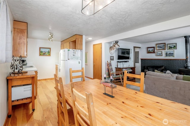 100 Aspen Ln, Packwood, WA 98361 - dining space with light wood finished floors, a textured ceiling, a wood stove, recessed lighting, and baseboards
