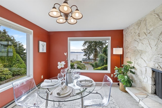 327 Priest Point Dr NW, Tulalip, WA 98271 - dining room with healthy amount of natural light, a chandelier, a fireplace, and baseboards