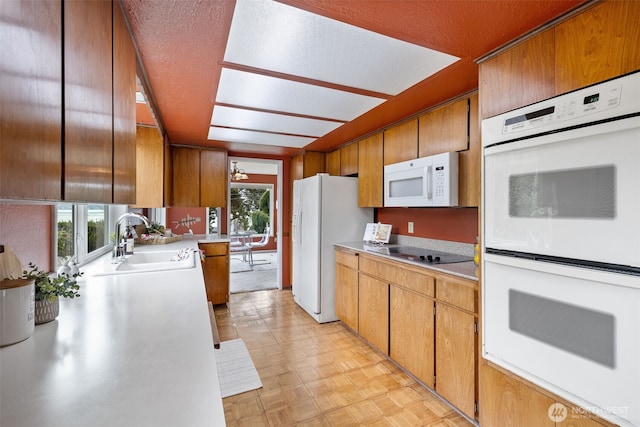 327 Priest Point Dr NW, Tulalip, WA 98271 - kitchen featuring white appliances, a sink, light countertops, and brown cabinetry