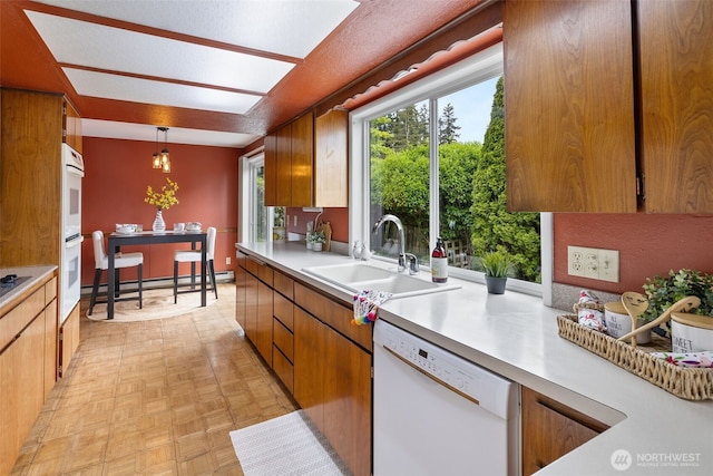 327 Priest Point Dr NW, Tulalip, WA 98271 - kitchen with white appliances, a sink, light countertops, and hanging light fixtures