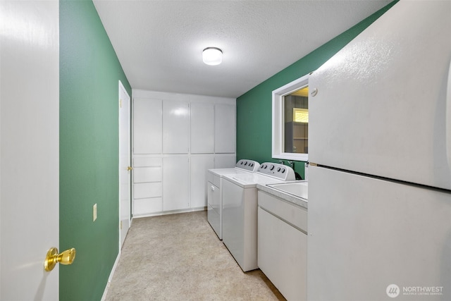 327 Priest Point Dr NW, Tulalip, WA 98271 - washroom with a textured ceiling, washer and dryer, cabinet space, and light carpet