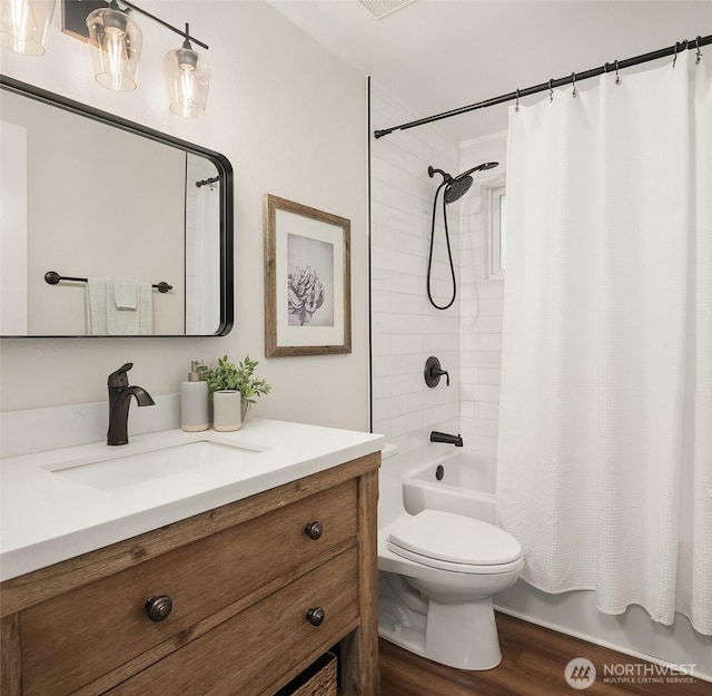 bathroom with shower / bath combination with curtain, toilet, wood finished floors, and vanity