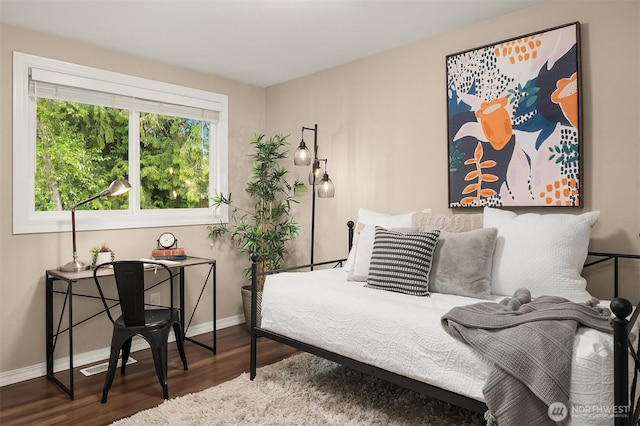 bedroom with wood finished floors and baseboards