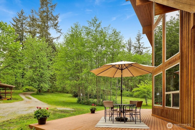 deck featuring a lawn and outdoor dining space