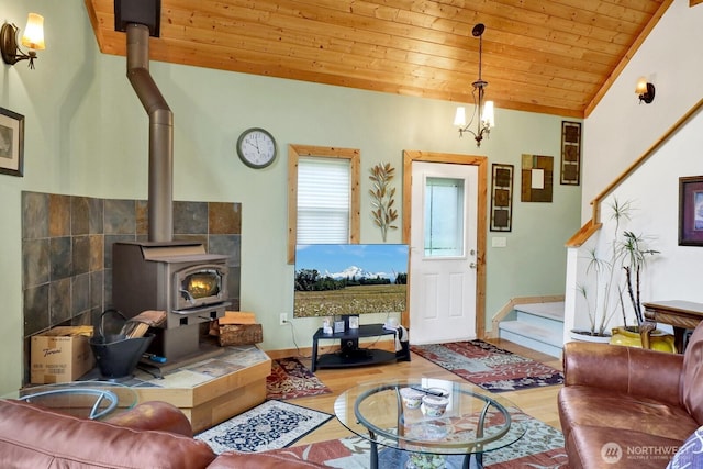 living room featuring a wood stove, wood ceiling, wood finished floors, baseboards, and lofted ceiling